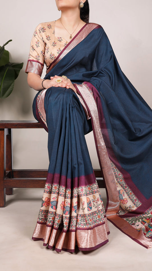 Woman wearing a blue printed tasar silk saree with viscose border.