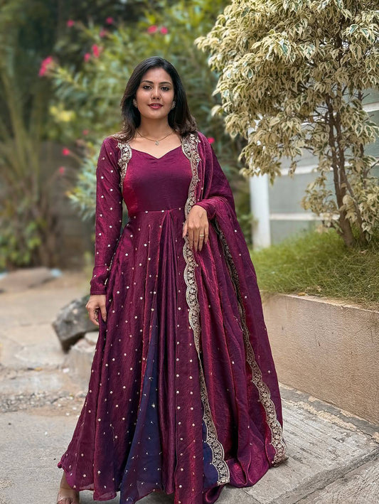 Flared wine Anarkali gown featuring delicate gold accents and a flattering silhouette.