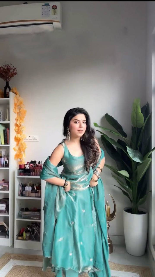 Model wearing a teal designer gown with pants and dupatta.