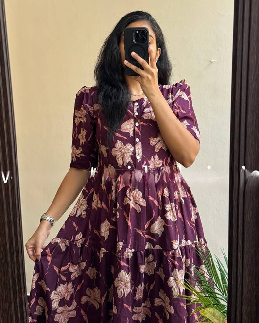 Close-up of the Moringa Maxi dress in plum with white floral print. Features button-down design and short sleeves.