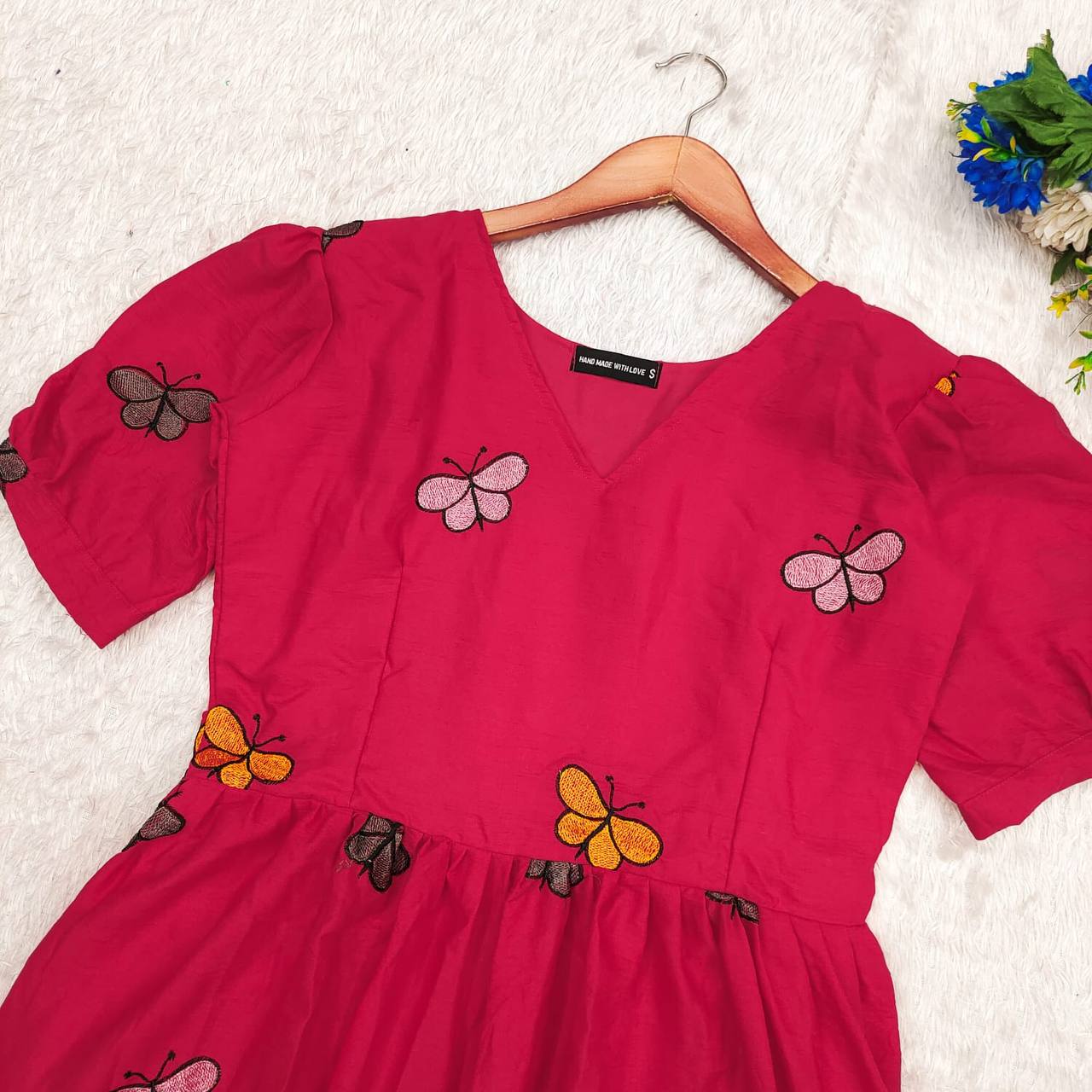 Close up of the pink Butterfly Maxi Dress showing the butterfly print near the neckline.