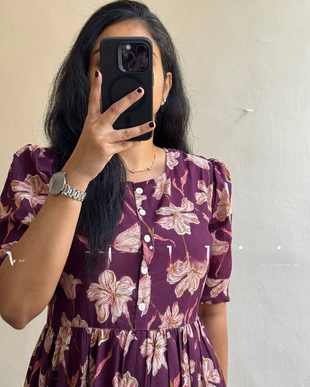 Close-up of the Moringa Maxi dress in plum with a floral pattern. Focus on the button detail and sleeve design.