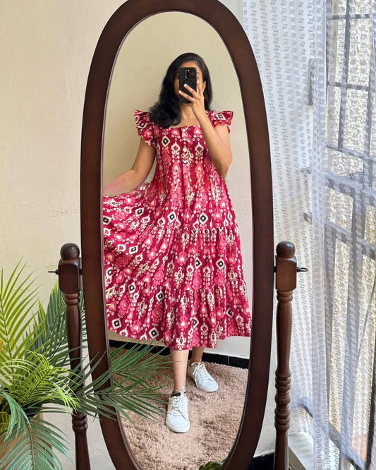 Woman twirling in a Dhano Maxi pink Patola dress, reflected in a mirror.
