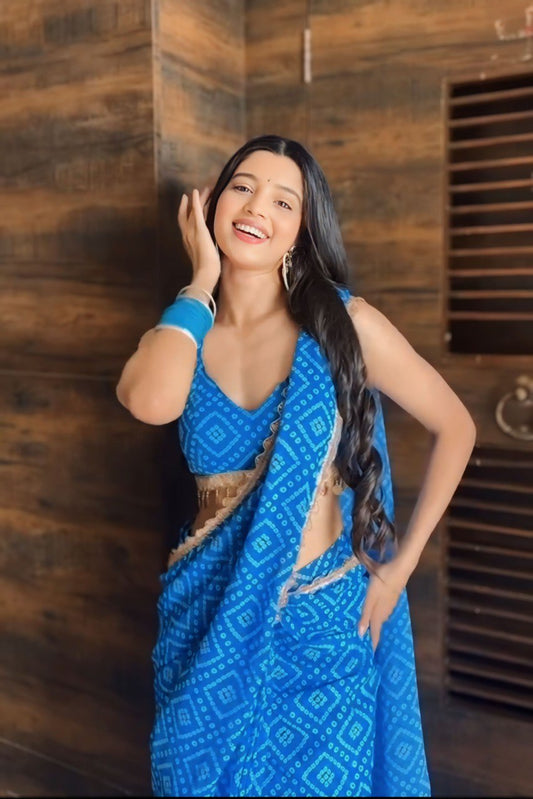 Smiling woman wearing a stylish blue ready to wear saree with matching bangles.