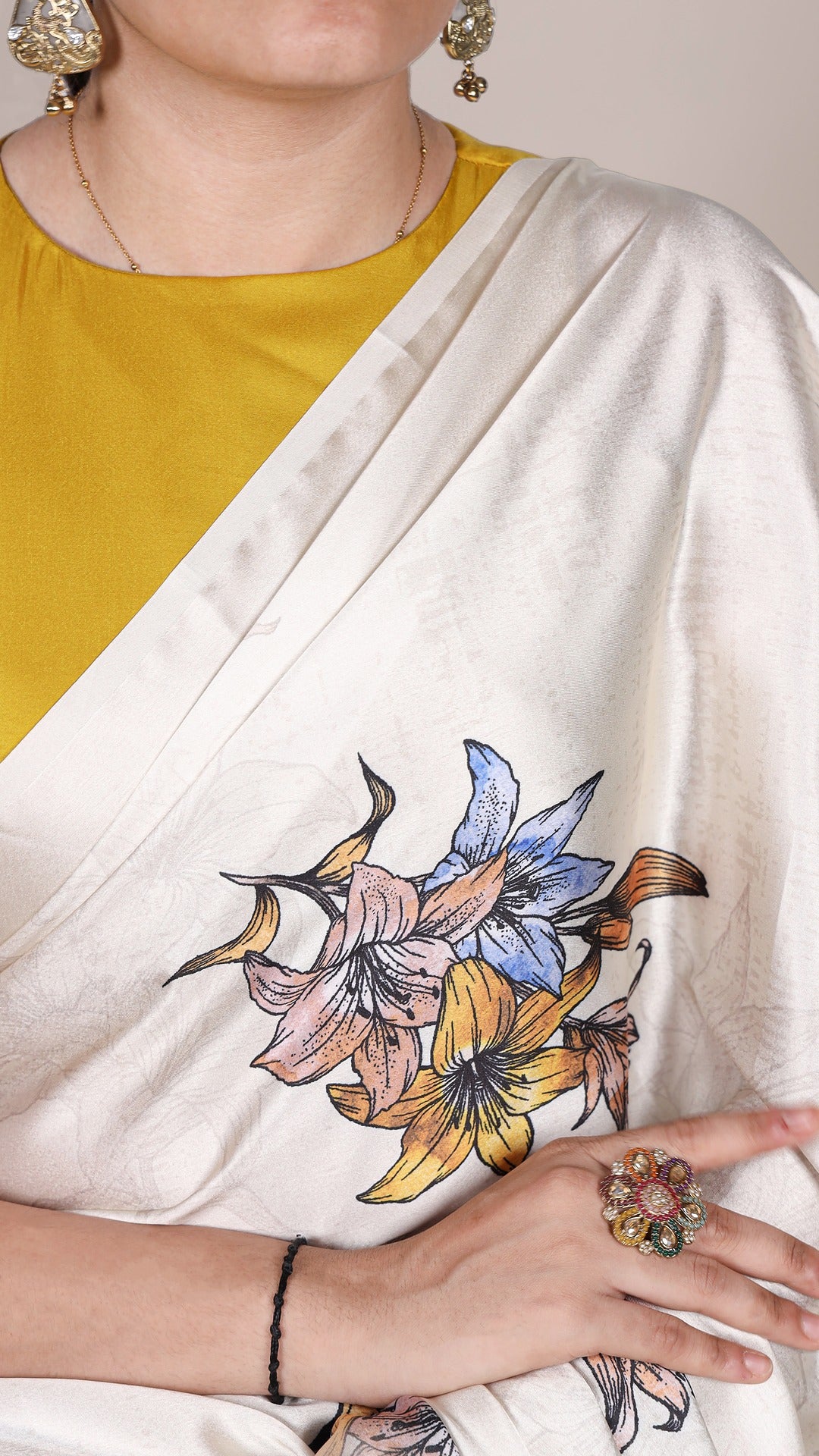 Satin saree featuring bright floral accents.