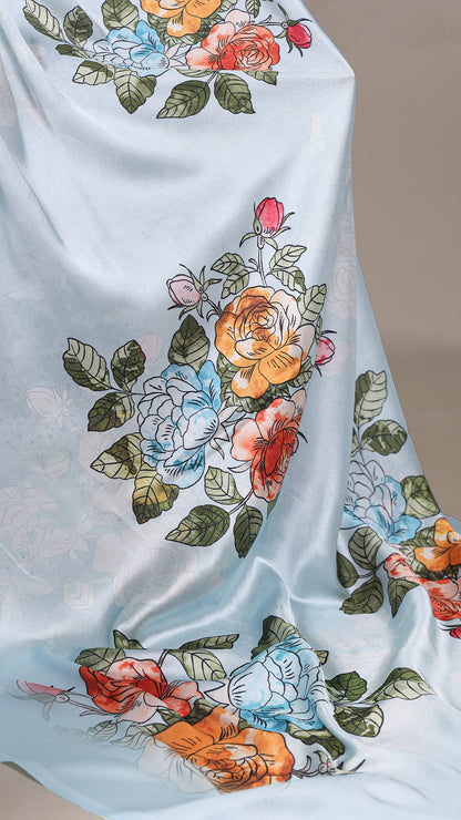 Close-up of floral print on a satin saree, light blue fabric.