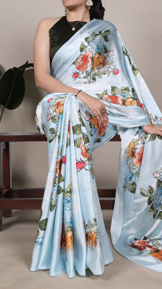 Elegant light blue satin saree with vibrant floral prints.