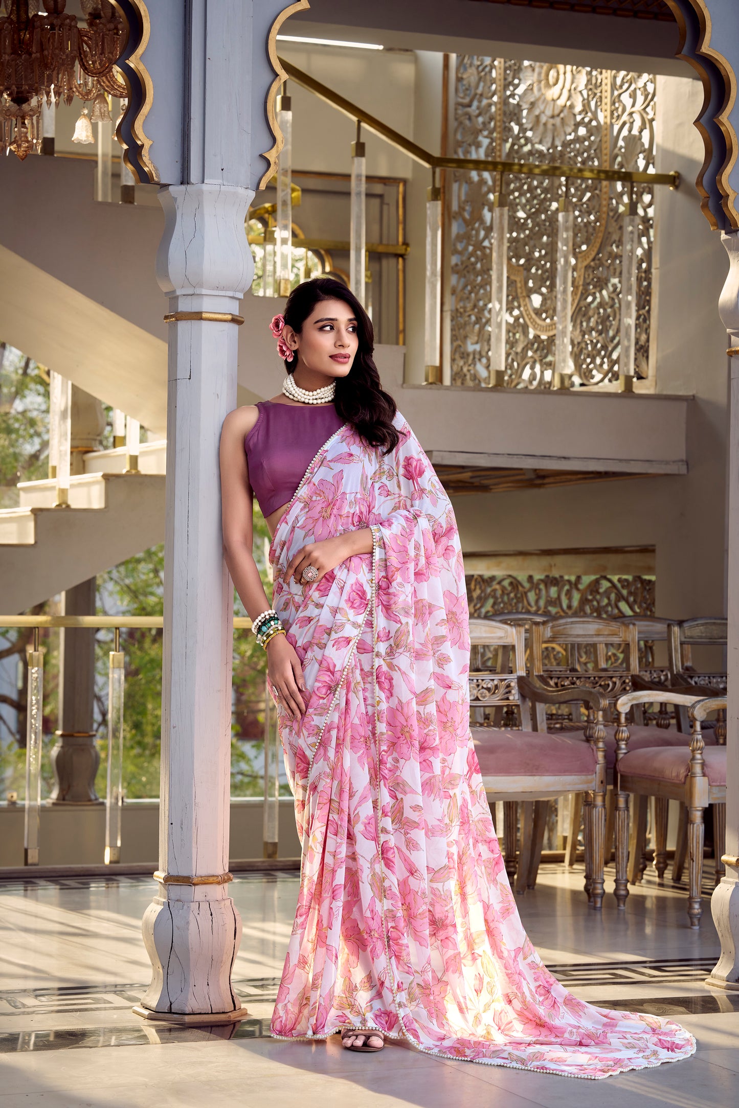 Full shot of a woman posing in a light purple floral print saree.