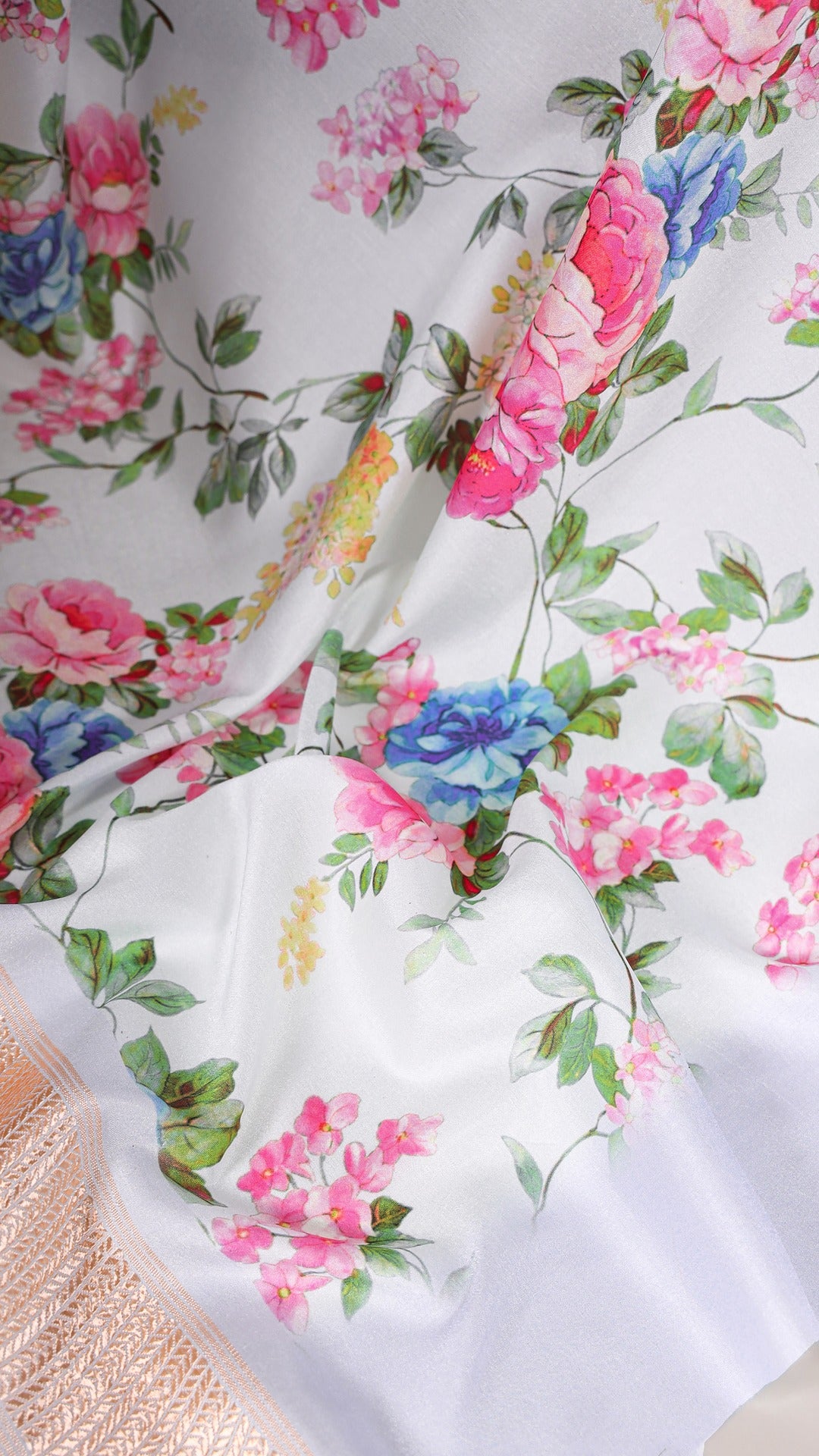 Close-up of the vibrant floral pattern on the sky blue saree fabric.