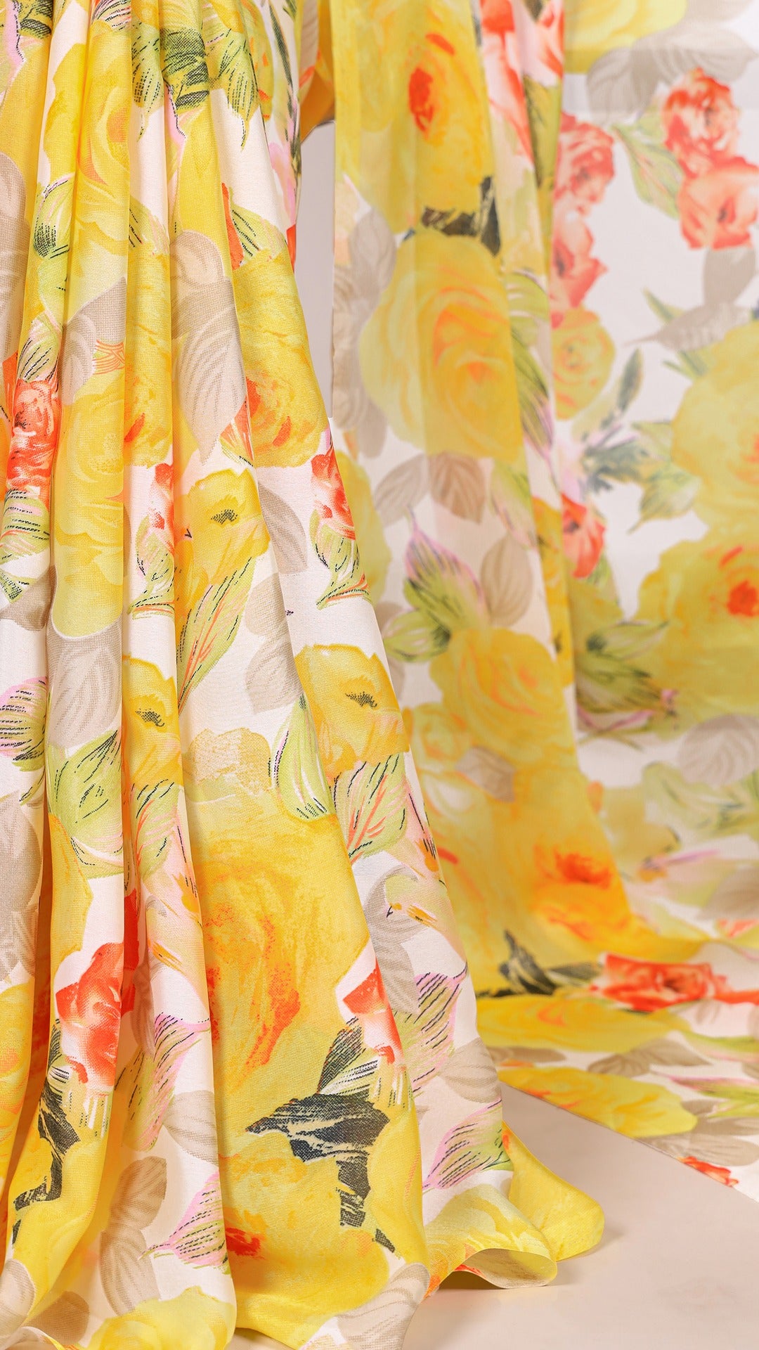 Draped yellow floral satin saree showing the soft fabric texture.