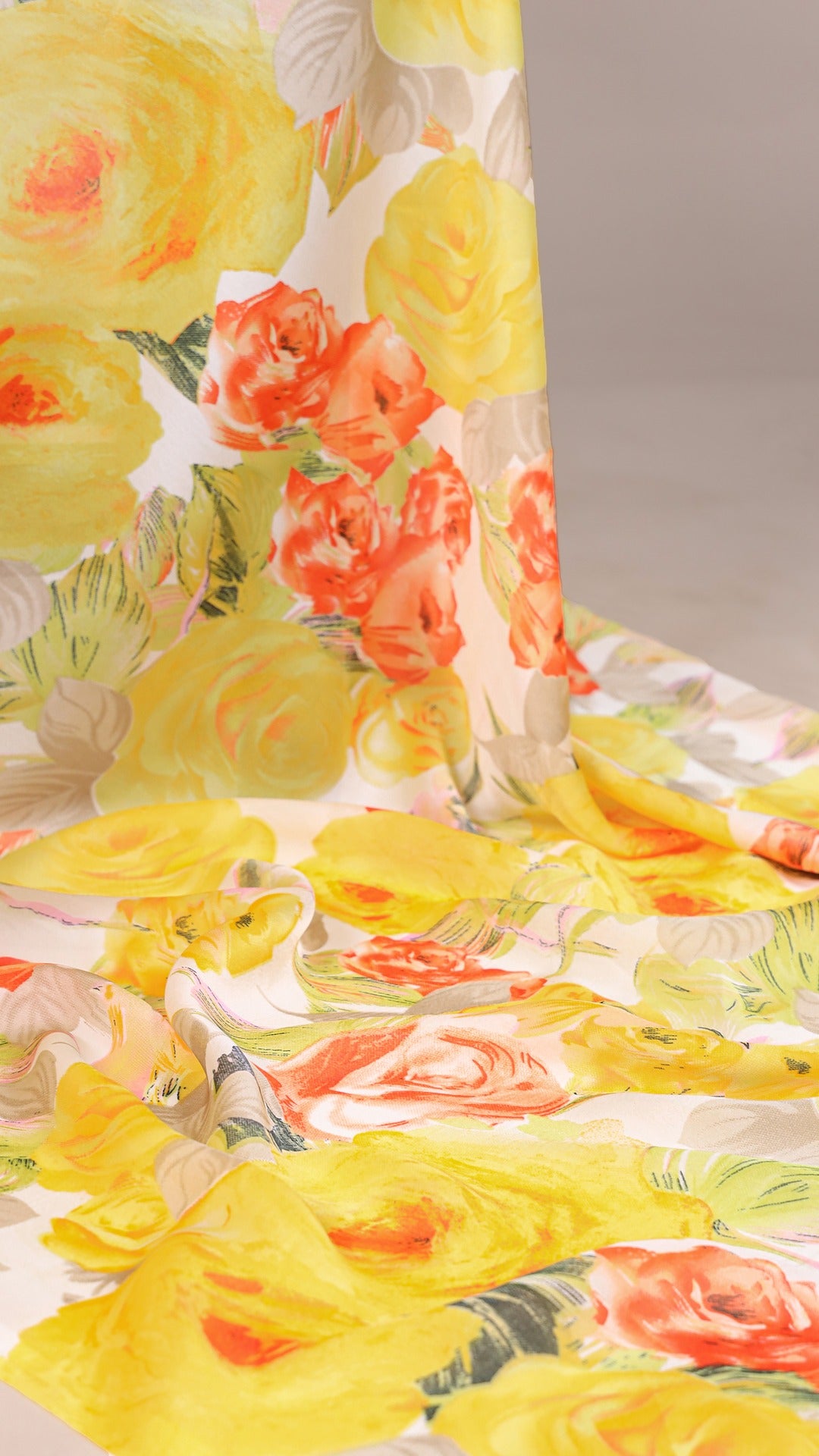 Detailed view of yellow floral print on luxurious satin saree fabric.