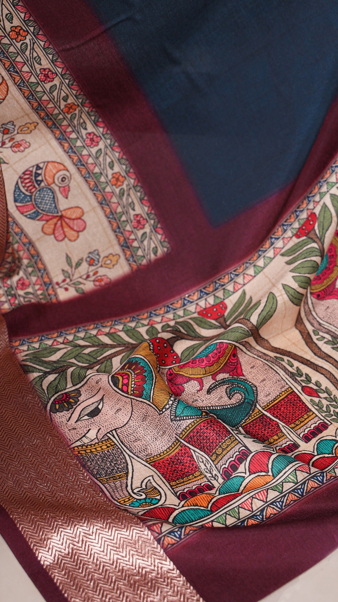 Close-up of the saree's edge, featuring printed bird and elephant motifs.