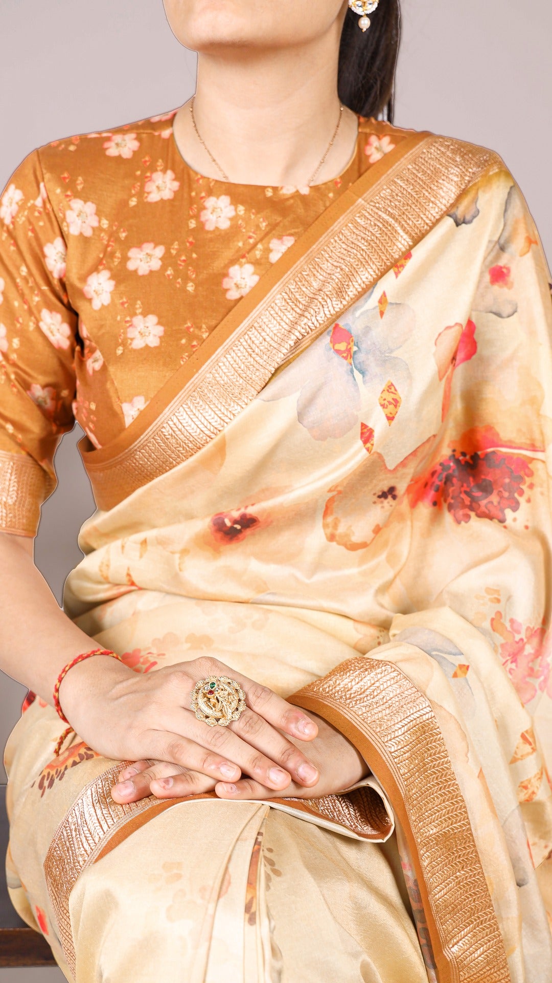 Close-up of floral saree with matching blouse and jewelry, showcasing the saree's design.