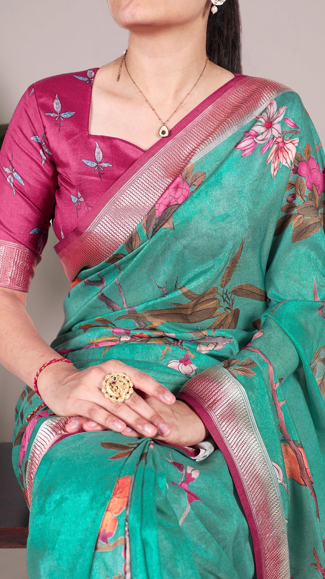 Close-up of floral saree with matching blouse and jewelry, showcasing the saree's design.