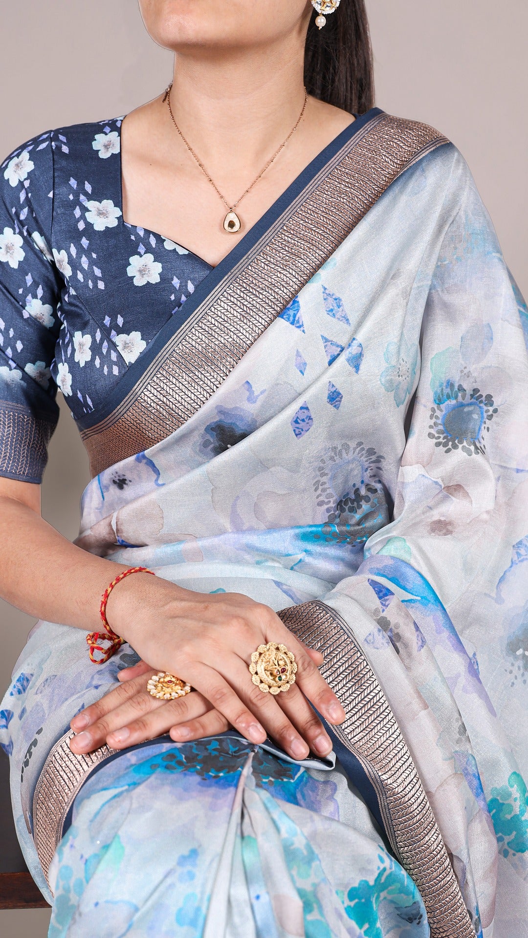 Close-up of floral saree with matching blouse and jewelry, showcasing the saree's design.