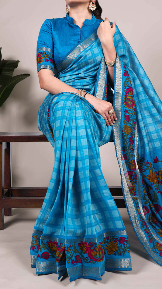 Woman wearing blue checked saree with floral details.