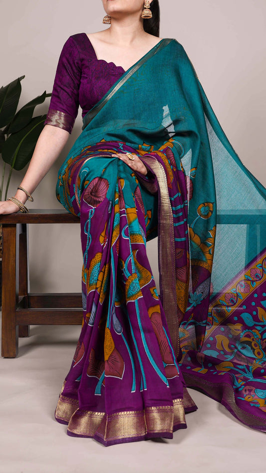 Teal and purple saree with nature-inspired design and zari border.