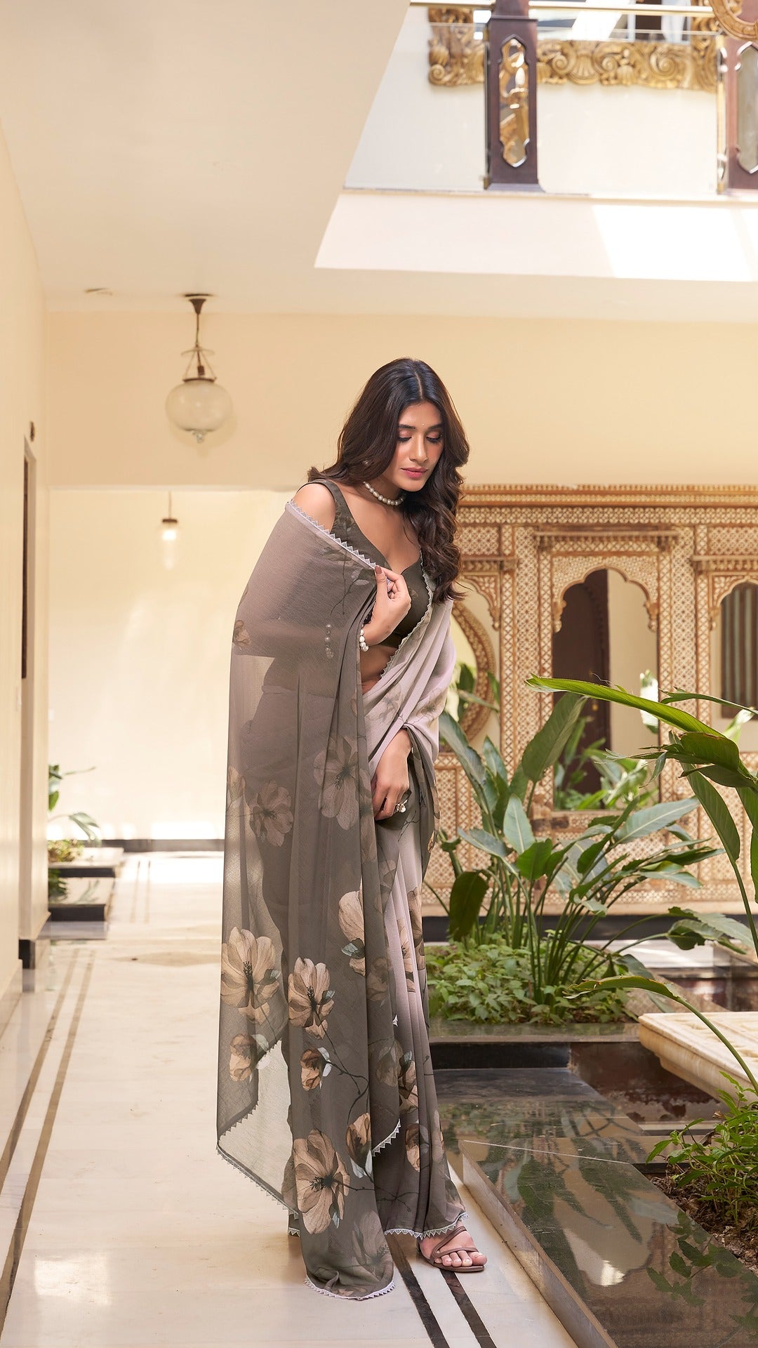 Model wearing a brown floral print saree with a light border.