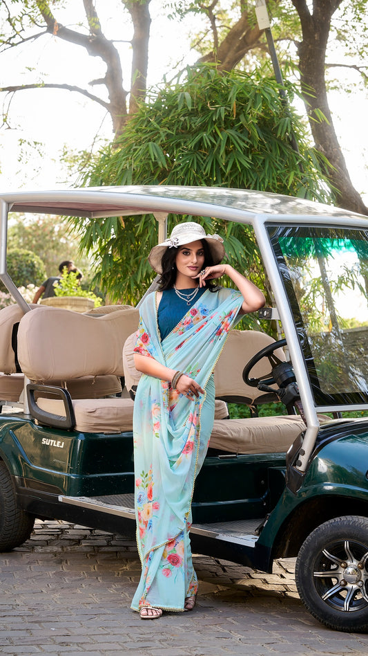 Woman in a stylish light blue floral saree with pearl lace.