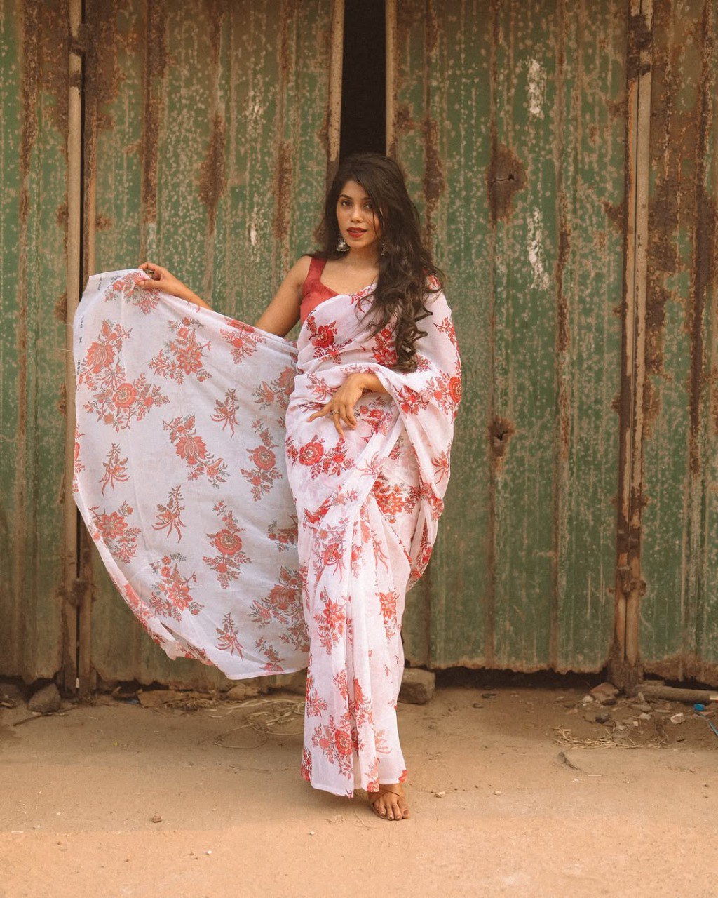 Close-up of a stylish woman in an off-white and red floral saree.