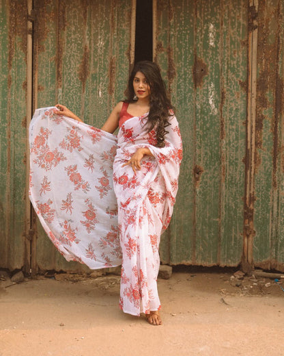 Close-up of a stylish woman in an off-white and red floral saree.