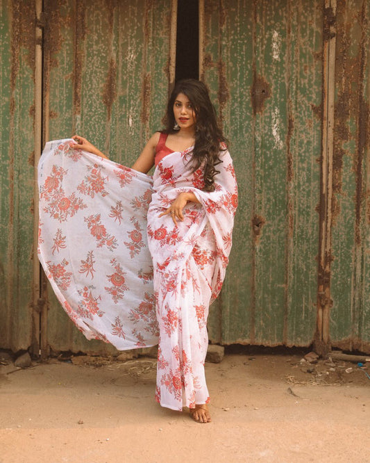 Close-up of a stylish woman in an off-white and red floral saree.