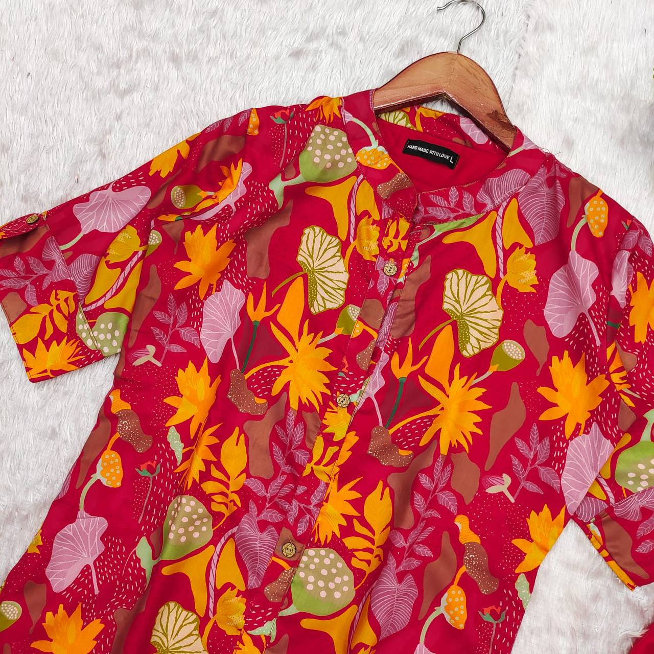 Red Forest kurti laid flat, showing vibrant floral print, elbow sleeves, and 'Hand Made With Love' label.