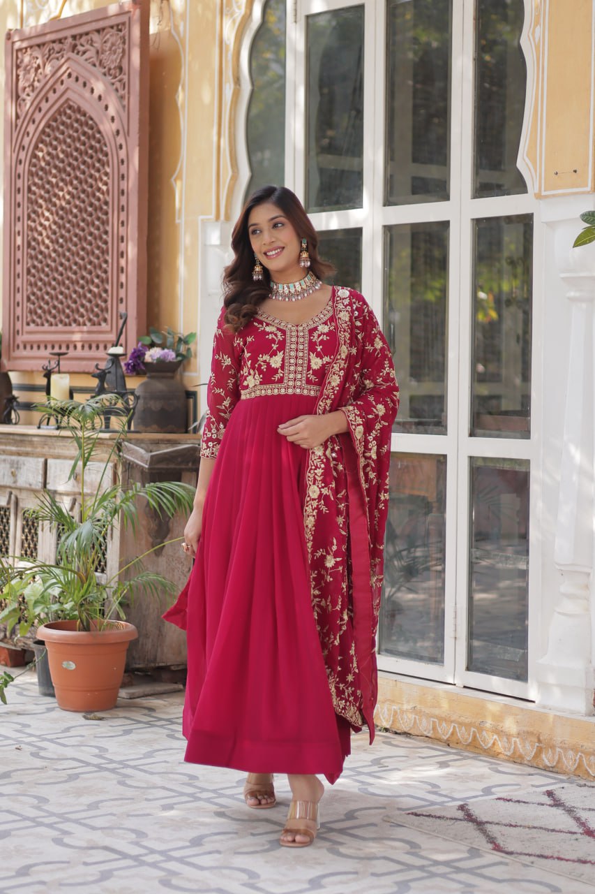 Smiling model in a pink premium zari embroidered Indian gown with dupatta.