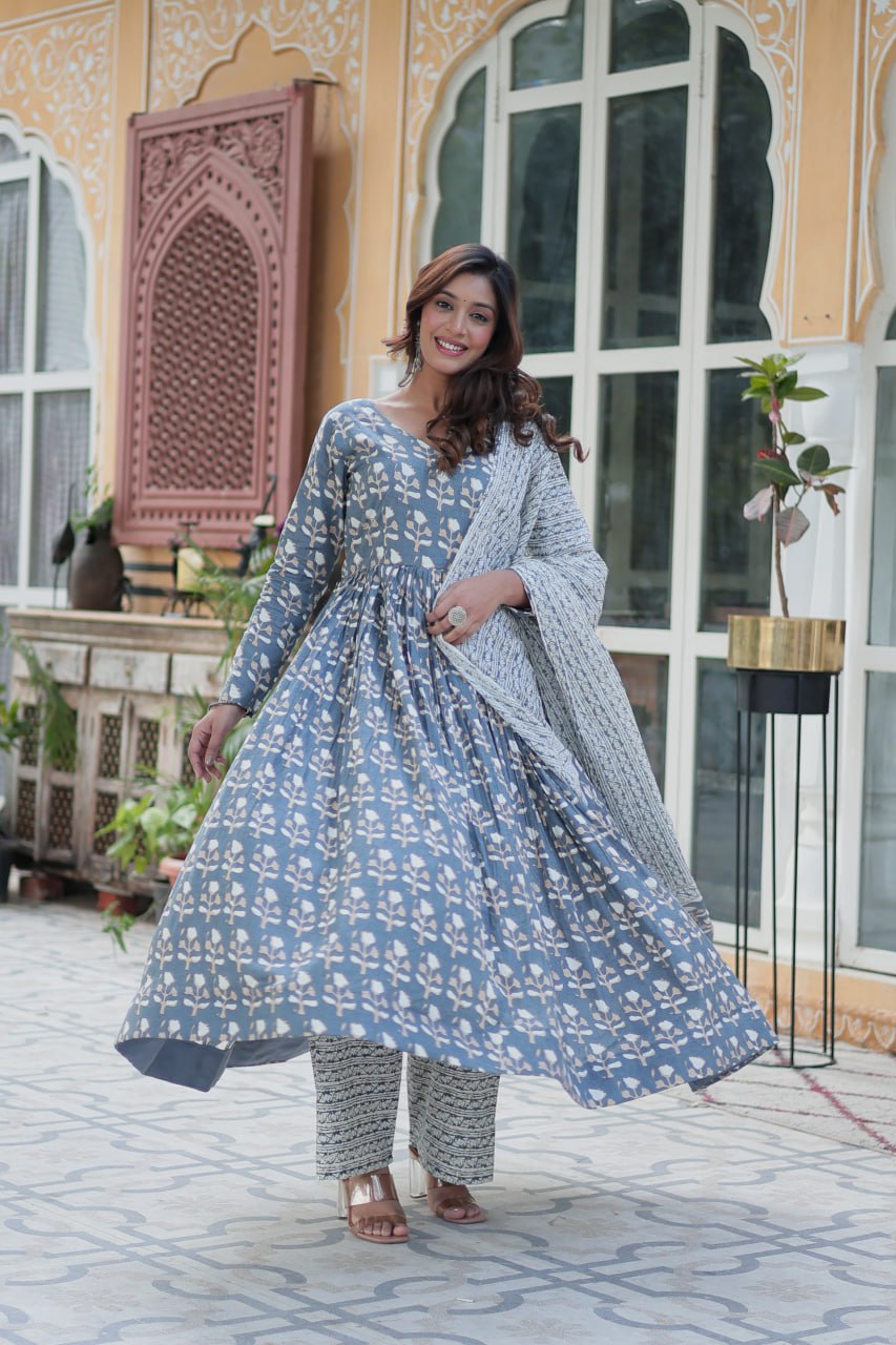 Woman poses in orange pure cotton kurti set with matching elastic-waist pants and lightweight dupatta.