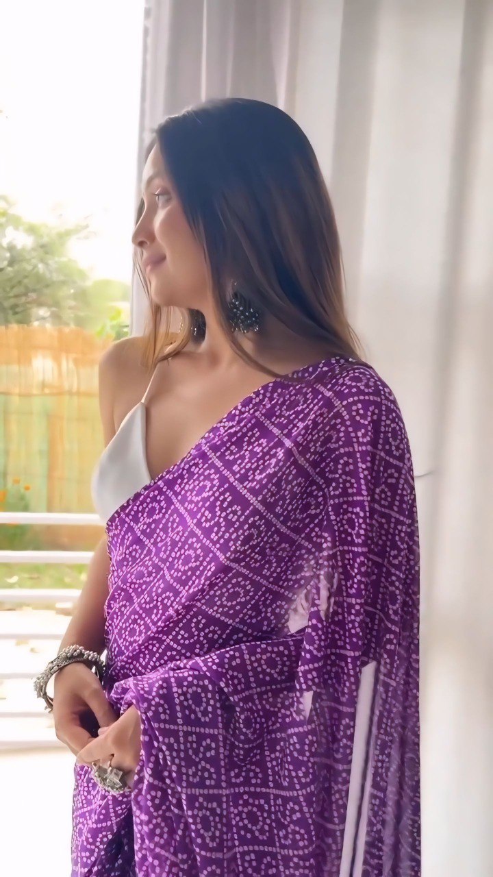 Profile view of a woman in a stylish purple printed georgette saree.