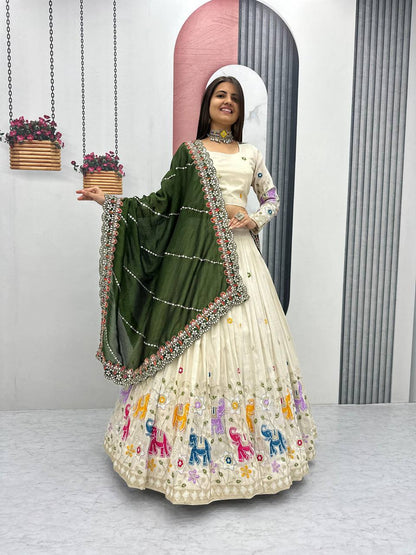 Woman in an off-white lehenga choli with elephant embroidery and an olive green dupatta.