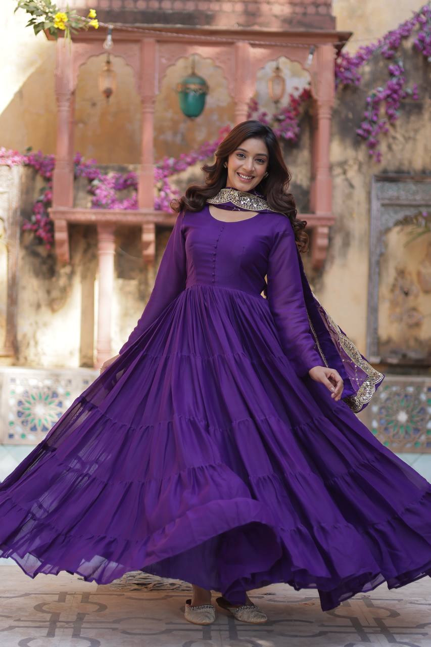 Woman in a purple flared gown with an embroidered dupatta, showcasing the gown's flair.