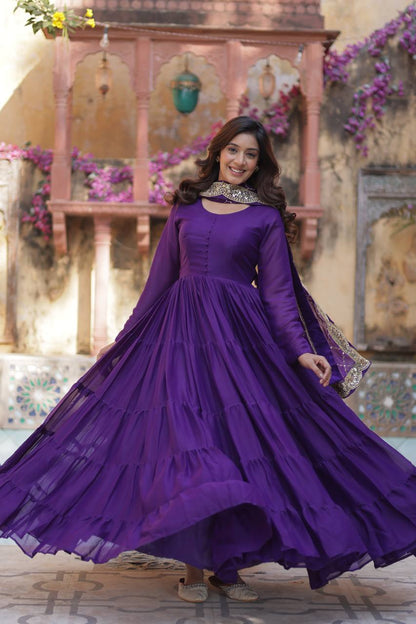 Woman in a purple flared gown with an embroidered dupatta, showcasing the gown's flair.