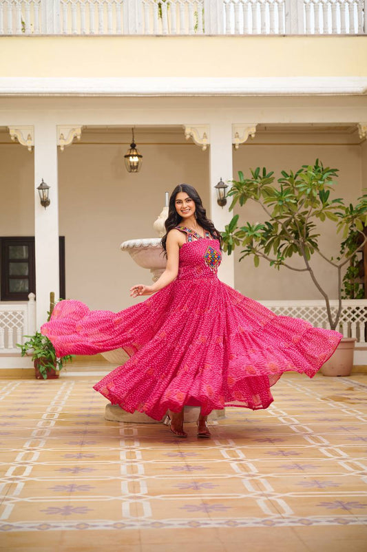 Woman in radiant pink Bandhani Gamathi work gown with intricate mirror and codi detailing.