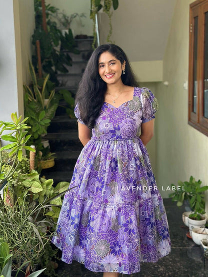 Close-up of purple floral print maxi dress in sunlight with greenery.