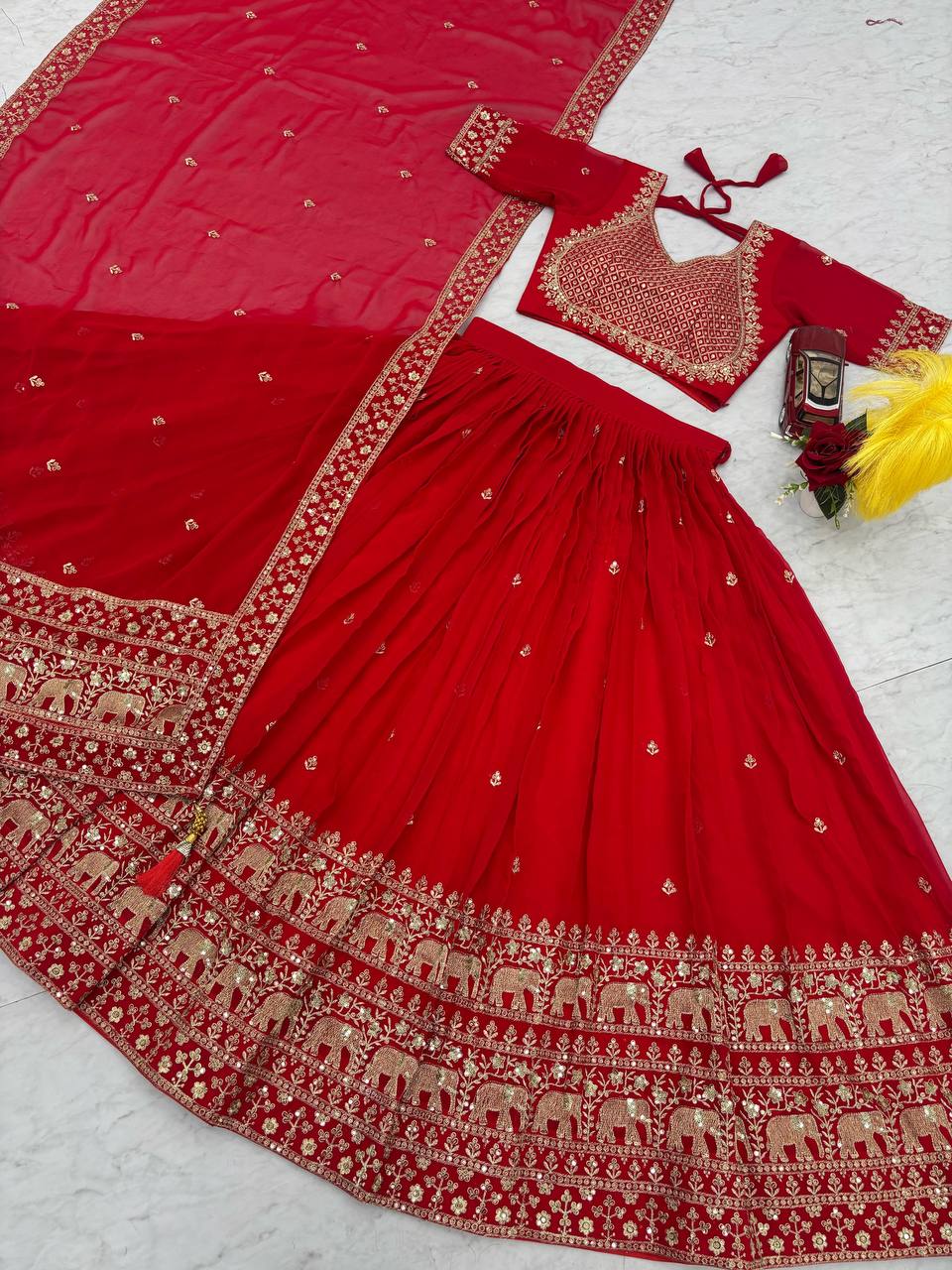 Detailed view of red lehenga choli with gold embroidery.