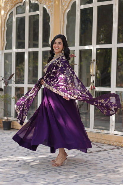 Model smiling in a premium purple zari embroidered Indian gown with dupatta.