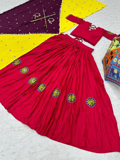 Pink lehenga spread out with floral embroidery, matching choli, and two-tone yellow and purple dupatta beside.