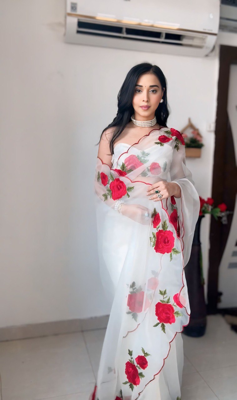Detailed view of the red rose embroidery on the elegant white saree.