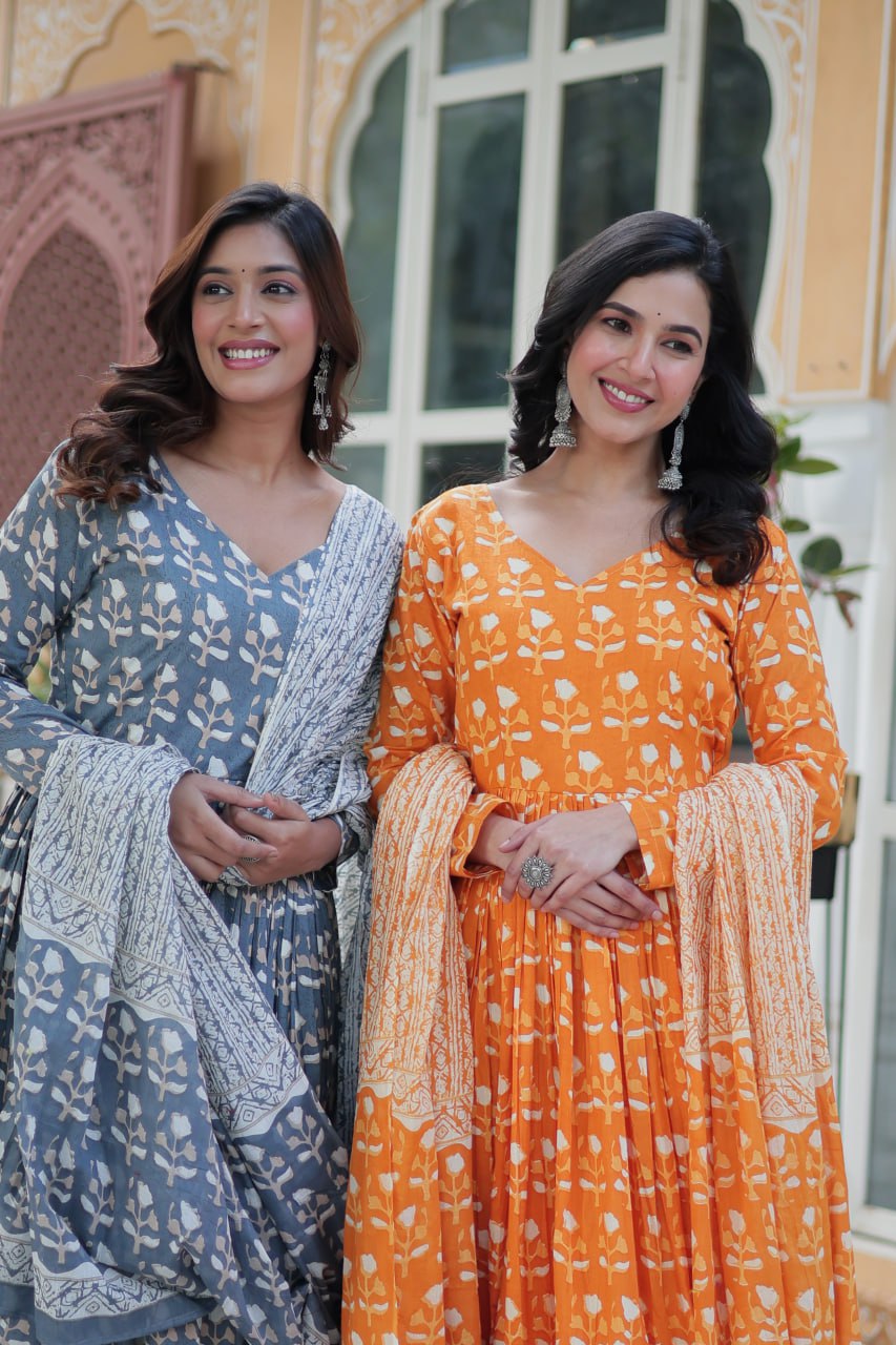 Two women modeling orange and blue pure cotton kurti sets, each styled with coordinated dupattas.
