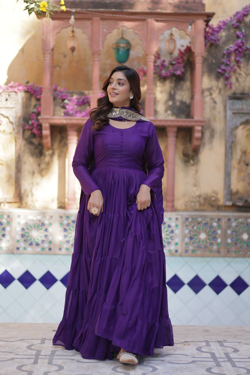 Woman wearing a long-sleeved purple flared gown with an embroidered dupatta.