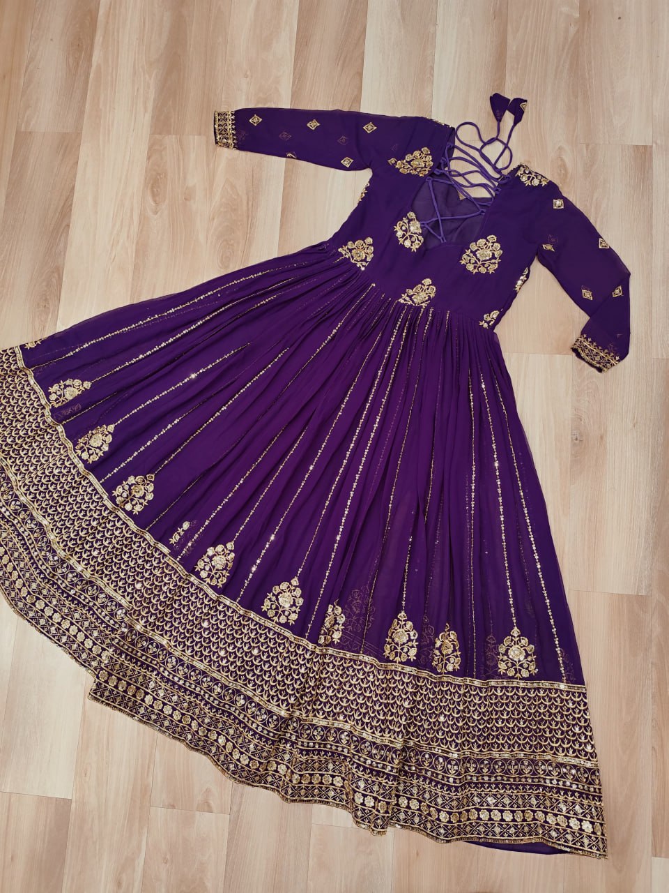 Designer purple gown with zari embroidered border and 3-meter flair.