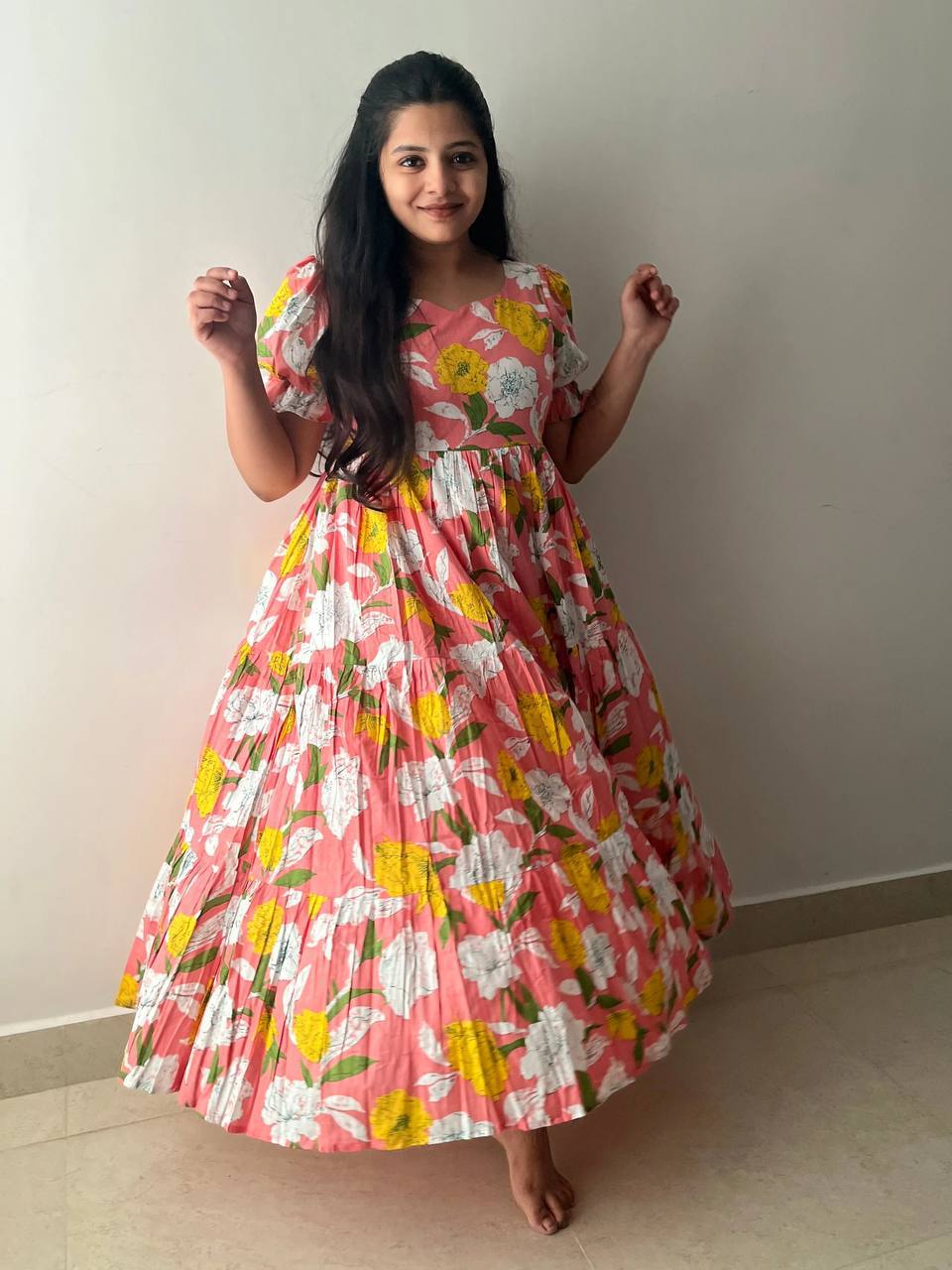 Full view of a woman in a pink floral cotton maxi dress.