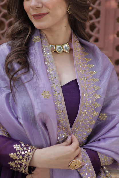 Close-up of the neckline and fabric of a purple designer gown.