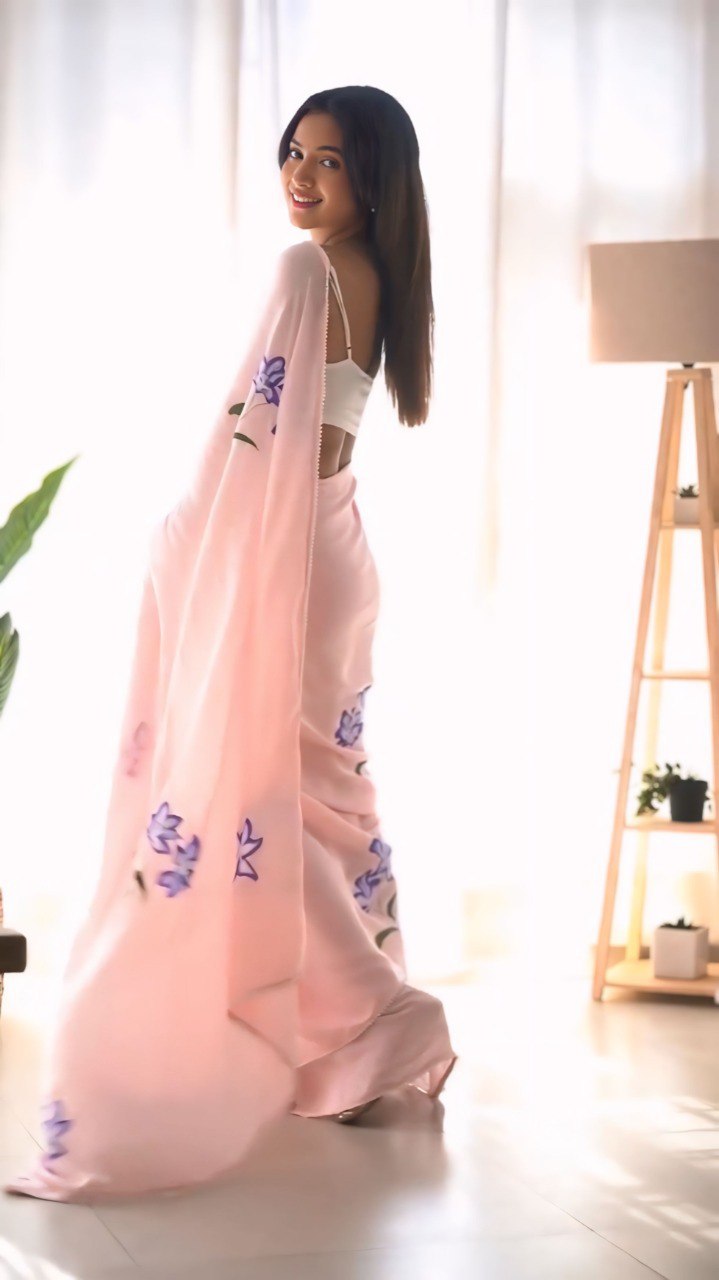 Pink georgette saree with a delicate floral pattern.