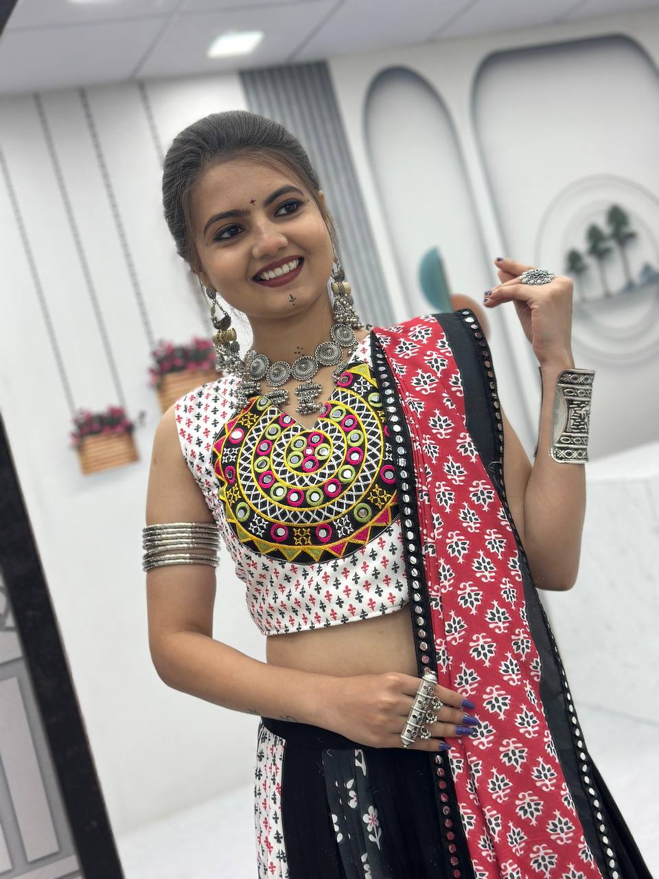Closeup of Gamathi work choli, statement necklace, and red folk print dupatta for Navratri.