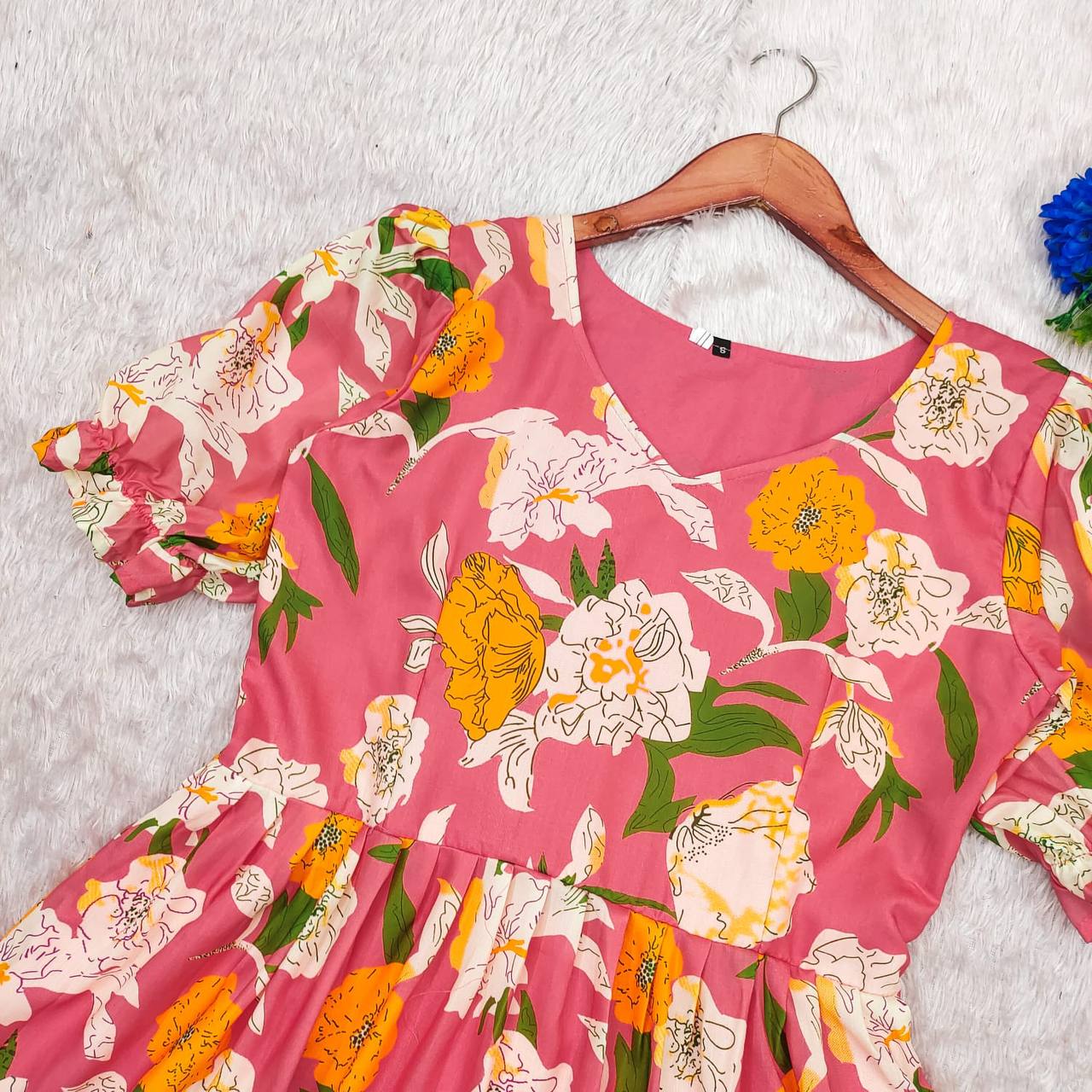 Close-up of the pink floral maxi dress on a hanger, showcasing the floral print.