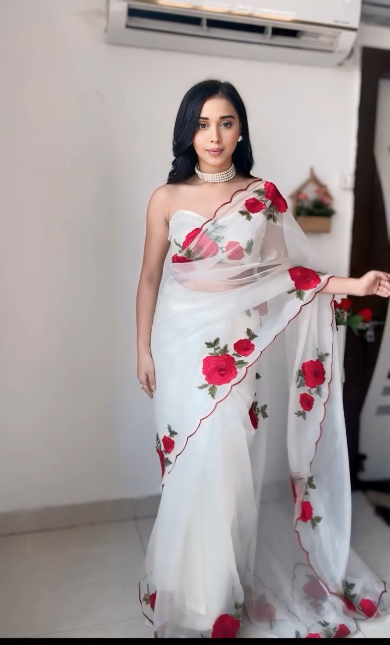 Close-up of the ready-to-wear white organza saree with red rose print.