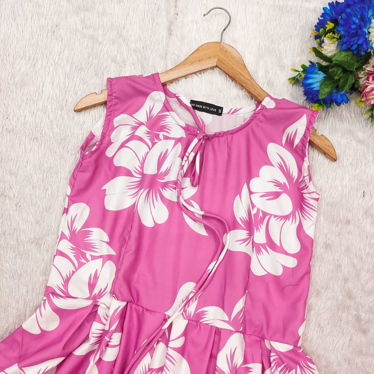 Close-up of pink blossom cotton dress on hanger, South Indian style.
