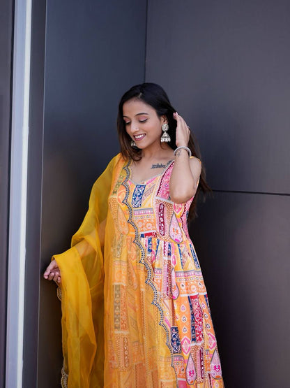 Stylish yellow Anarkali suit with colorful print and net dupatta detail.